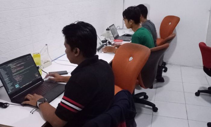 Tim pengembang bekerja bersama di kantor